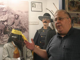 Retired Army Col. Joseph Abodeely, president of the Arizona Military Museum in Phoenix, explains an exhibit.