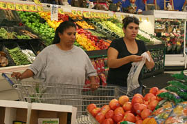Gloria Espinoza, left, with friend Herlinda Arvizu, uses her Supplemental Nutrition Assistance Program benefits to shop at a grocery store seven blocks from her South Tucson home. She walks to and from the store.