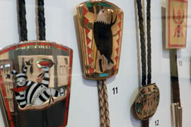 A collection of bolo ties hang in the Heard Museum exhibit. Contemporary artists are working with new materials, such as stainless steel, to create a more modern bolo tie for the times.