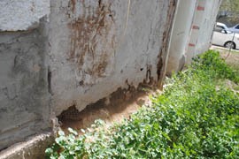 The adobe is deteriorating on the wall of this 19th century home.