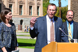 State Comptroller D. Clark Partridge addresses a news conference at which the Arizona Public Interest Research Group gave Arizona an A-minus for government transparency, mainly because of a database of state expenditures operated by Patridge's office. Listening are Serena Unrein, left, a public interest advocate for Arizona PIRG, and Byron Schlomach, an economist with the Goldwater Institute.