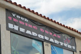 A sign welcoming spring breaker goers hangs on the front of Beachcombers, a retail shop that sells spring break related items such as board shorts and bikinis.