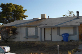 This Phoenix home was one of 72 area bank-owned properties investigated by the National Fair Housing Alliance, which said banks neglect foreclosed homs in largely Hispanic neighborhoods. This house had a damaged roof, trash, overgrown shrubs and boarded-up windows and garage door.