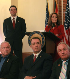 Steve Smith, at back left, looks on as Rep. Michele Bachmann, speaks about border issues at a press conference at the Arizona State Capitol on Oct. 17, 2011.