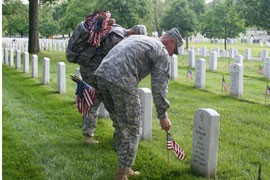 Soldiers carrying hundreds of American flags work their ways down the row of headstones at Arlington National Cemetery in Virginia in preparation for Memorial Day.