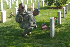 A soldier pauses while placing flags on the graves Arlington National Cemetery in Virginia in preparation for Memorial Day ave the military cemetery.