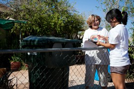 During a visit to an east Phoenix neighborhood, volunteer Yvette Saenz, right, registers Sylvia Gutierrez for the permanent early voter list.