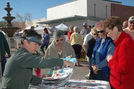 Women visit a vendor's table in downtown Yuma during Yuma Lettuce Days, an annual March festival of local food producers and others in the town.