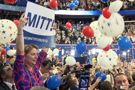 Delegates on the floor of the Republican National Convention make their support known for presidential nominee Mitt Romney on the last night of the convention in Tampa.