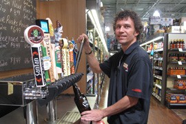 Dennis Peoples, an employee of a Total Wine and More outlet in Phoenix, fills a jug called a growler with draft beer. A new state law allows bars and stores selling wine and beer to fill growlers for customers.