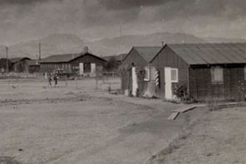 The camp at Poston included barracks for relocated families as well as a police office and barber shop, shown in this historical photo, and other service buildings.