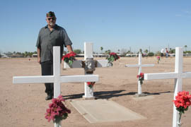 Ernest Garcia stands by the graves of his grandmother and seven cousins at Cementerio Lindo near downtown Phoenix.