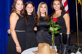 Women attending Thursday's dinner of the Border Patrol Foundation in Washington pose with a hat, boots and holster, three items used to symbolize lost agents.