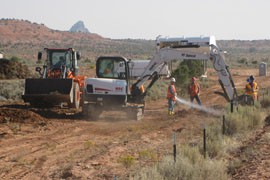 The process of cleaning up the Cove, Ariz., uranium transfer station involved digging up and hauling away tainted soil while workers hosed down the job to keep dust down.