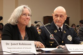 Chaska, Minn., Police Chief Scott Knight looks on as Emily Nottingham testifies to a panel of House Democrats considering action to curb gun violence. Nottingham's son, Gabe Zimmerman, was killed in a 2011 mass shooting in Tucson.