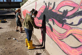 Ashley Macias (right) and Isaac Caruso spray paint their temporary artwork, 