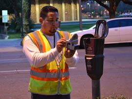 Xavier Newell, a parking meter specialist for the city of Phoenix, inspects a meter downtown.
