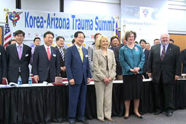 Gov. Jan Brewer and other Arizona officials pose with representatives from South Korea at the start of a three-day summit on trauma care.