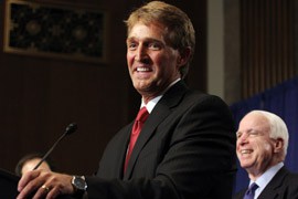 Arizona Sens. Jeff Flake, at podium, and John McCain share a laugh during the news conference at which they and six other senators unveiled a sweeping, bipartisan immigration-reform bill.