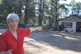 A resident of Mountainaire points to her house, which was moved on to federal property when the government moved national forest boundary lines that had been erroneously placed decades earlier.
