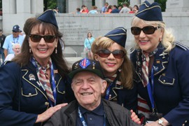 The Ladies for Liberty, a singing group from Kentucky that performed at the World War II Memorial Thursday, poses with a Tucson-area veteran of the war.