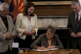 White Mountain Apache Chairman Ronnie Lupe, left, looks on as Interior Secretary Sally Jewell signs a water-rights agreement with the tribe. Also on hand were Rep. Ann Kirkpatrick, D-Flagstaff, and former Arizona Sen. Jon Kyl.
