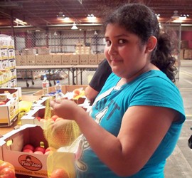 A volunteer helps bag tomatoes at the Yuma Community Food Bank.