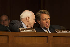 Arizona Sens. John McCain, left, and Jeff Flake speak during the Senate Foreign Relations Committee meeting at which senators gave preliminary approval to a resolution allowing the president to take military action against Syria.