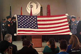 First responders unveil a flag that flew over Ground Zero at Wednesday's 9/11 commemoration at Phoenix City Hall.