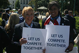 Stacy Santimaw, left, and Jennifer Hutt, US Airways flight attendants based in Phoenix, hold up signs at a rally for the merger of US Airways and the American Airlines on Capitol Hill.