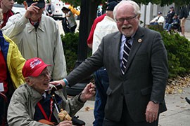 Rep. Ron Barber, D-Tucson, laughs while greeting an Honor Flight veteran at the World War II Memorial Monday.