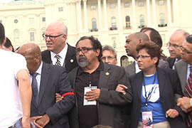 Rep. Raul Grijalva, D-Tucson, center, links arms with other members of Congress before being arrested in front of the Capitol as part of a rally in support of immigration reform.