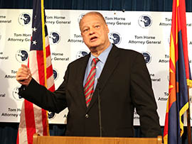 Attorney General Tom Horne addresses a news conference at which he detailed an indictment accusing 21 Tucson-based members of the Arizona Air National Guard of fraudulently collecting stipends for housing and other temporary-duty expenses.