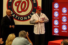 Former Arizona Diamondbacks player and coach Matt Williams tries on his new uniform, after being introduced as the new manager of the Washington Nationals by Washington General Manager Mike Rizzo, left.