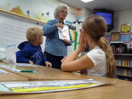 Mardy Zimmermann, a retiree volunteering with the Earth Science Museum, teaches students at Desert Mountain Elementary School in Queen Creek, about Arizona's rocks and minerals.