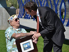 Secretary of State Ken Bennett shakes hands with Albert Thomas, a 91-year-old Pearl Harbor survivor, at a ceremony commemorating a postage stamp honoring the USS Arizona Memorial.