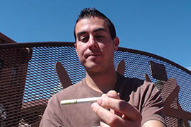 Chris Azimi, a Northern Arizona University student, smokes an electronic cigarette at a Flagstaff park. He said he's been tobacco-free for two months thanks to e-cigarettes.