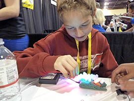 Matthew Burggraff, an eighth-grader at West Gilbert Charter School, pushes lights into Play-Doh that conducts electricity.