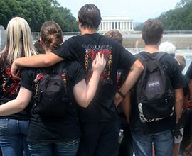 Torie Immn, left, and Erich Christiansen put their arms around each other as they and fellow Willow Canyon band members look over the National Mall.
