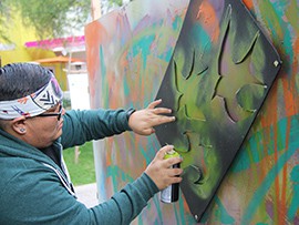 A Native American artist demonstrates the making of spray-painted street art at the Arizona Indian Festival at Scottsdale Civic Park.