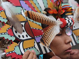 A young Hopi woman puts on a water maiden headdress for the Arizona Indian Festival’s opening dance performance.