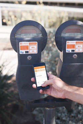 Three University of Arizona graduates annoyed with coin-only parking meters developed Park Genius, which allows motorists to pay for parking meters remotely.