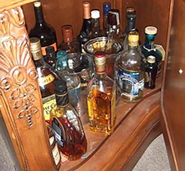 Bottles of alcohol sit in an unlocked cabinet that was accessible to children at one of 20 home day-care providers in Arizona audited by federal inspectors in 2013.