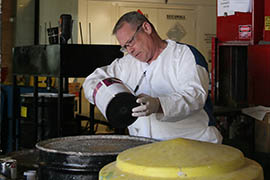 Rick Neiner Sr., a technician at Gilbert’s Household Hazardous Waste Facility, pours latex  paint into a drum mixing it with other paint that’s being recycled.