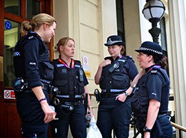 The bobbies in London speak outside Charing Cross Police Station Wednesday, August 1, 2012. Neither the bobbies nor civilians are permitted to carry weapons in London.