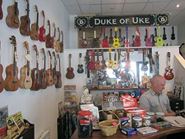 An employee surrounded by some of the many ukuleles sold at the Duke of Uke in London.